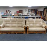 A wooden framed leather three seater settee and matching two seater settee with fitted drawers