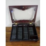A counter top display cabinet containing 40 miniature leather bound volumes