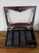 A counter top display cabinet containing 40 miniature leather bound volumes