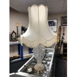 A cut-glass table lamp with shade on brass base