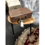 A vintage brown leather suitcase and a lamp table