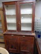 An antique glazed cabinet on cupboard base