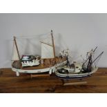 Two wooden model fishing trawlers on stand