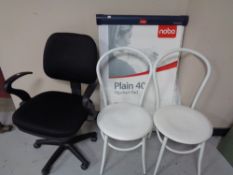 A swivel office chair together with a Nobo flip chart stand and two white metal tubular chairs