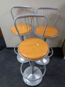 A set of three contemporary pine seated metal framed bar stools