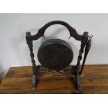 An antique gong and beater on oak stand
