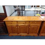 A pine triple door sideboard fitted with three drawers (af)