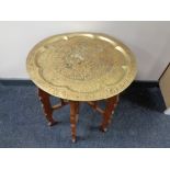 An Eastern brass topped folding table