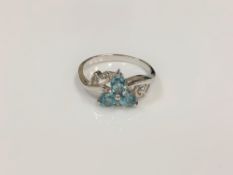 A silver dress ring set with blue stones,