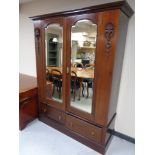 A Victorian mahogany double mirrored wardrobe fitted with two drawers