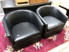A pair of black vinyl stitched tub chairs