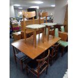 A twentieth century teak extending table and four rail backed dining chairs and further pair of