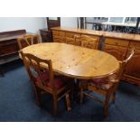 A pine drop leaf kitchen table together with four pine dining chairs