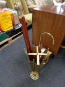 A brass umbrella stick stand containing two brass headed walking sticks,