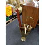 A brass umbrella stick stand containing two brass headed walking sticks,