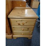 A pine three drawer bedside chest