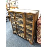 A 1930's triple door oak break fronted bookcase with leaded glass doors