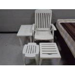 A white plastic steamer armchair together with two white coffee tables and pair of stools