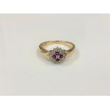 A 9ct gold diamond and ruby cluster ring, size P.