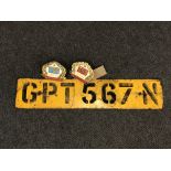 An old car number plate together with two continental bumper badges