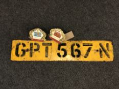 An old car number plate together with two continental bumper badges