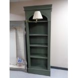 A set of tall painted shelves fitted with reading light