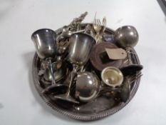 A circular plated tray containing servers and cutlery, plated goblets,