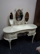 A cream and gilt dressing table fitted with five drawers and mirror