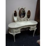 A cream and gilt dressing table fitted with five drawers and mirror