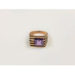 A 14ct gold 70's style ring set with a square cut purple stone, size K/L.
