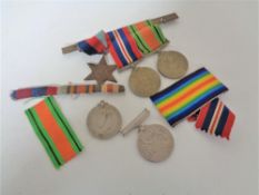 A group of three WWII medals on bar together with two further medals of the same war.