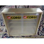 A painted mid century sliding glass door cabinet bearing Corgi advertisement