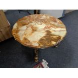 A shaped onyx topped coffee table on ornate brass base