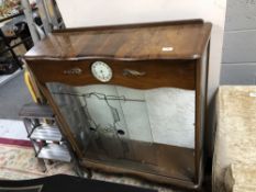 A walnut display cabinet fitted with a Smith's clock