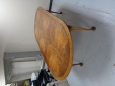 An oval walnut dining table on claw & ball feet