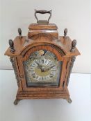 An oak cased Wuba Warnk mantel clock on raised feet with moon phase dial