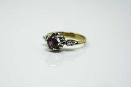 An 18ct yellow gold diamond set ring, the central stone possibly garnet, size O/P.