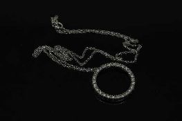 A white gold diamond set circular pendant on chain, pendant weight 1.