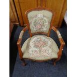 A stained beech salon armchair upholstered in tapestry fabric