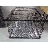 A folding black metal dog cage, height 74 cm, width 98 cm, depth 96 cm.