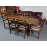 An oak refectory dining table together with six ladder backed chairs