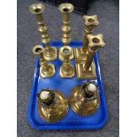 A tray of four pairs of brass candlesticks