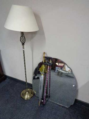 A frameless bevelled mirror, contemporary floor lamp with shade,