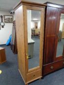 A narrow pine mirrored cupboard fitted with shelves and drawers beneath. 185 cm x 54.5 cm x 61.5 cm.