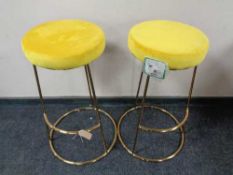 A pair of contemporary bar stools on metal bases
