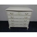 A cream and gilt five drawer chest