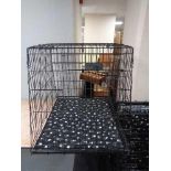 A folding black metal dog cage, height 70 cm, width 68 cm, depth 84 cm.