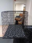 A folding black metal dog cage, height 70 cm, width 68 cm, depth 84 cm.