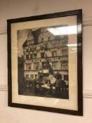 An etching depicting figures in a busy street, framed.