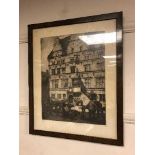 An etching depicting figures in a busy street, framed.